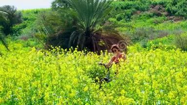 一片美丽的田野，高大的植物和黄色的花朵，<strong>还有</strong>一个带自行车的年轻女子